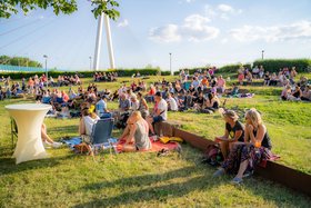 Menschen sitzen bei sonnigem Wetter auf der Wise der Goethe-Anlagen